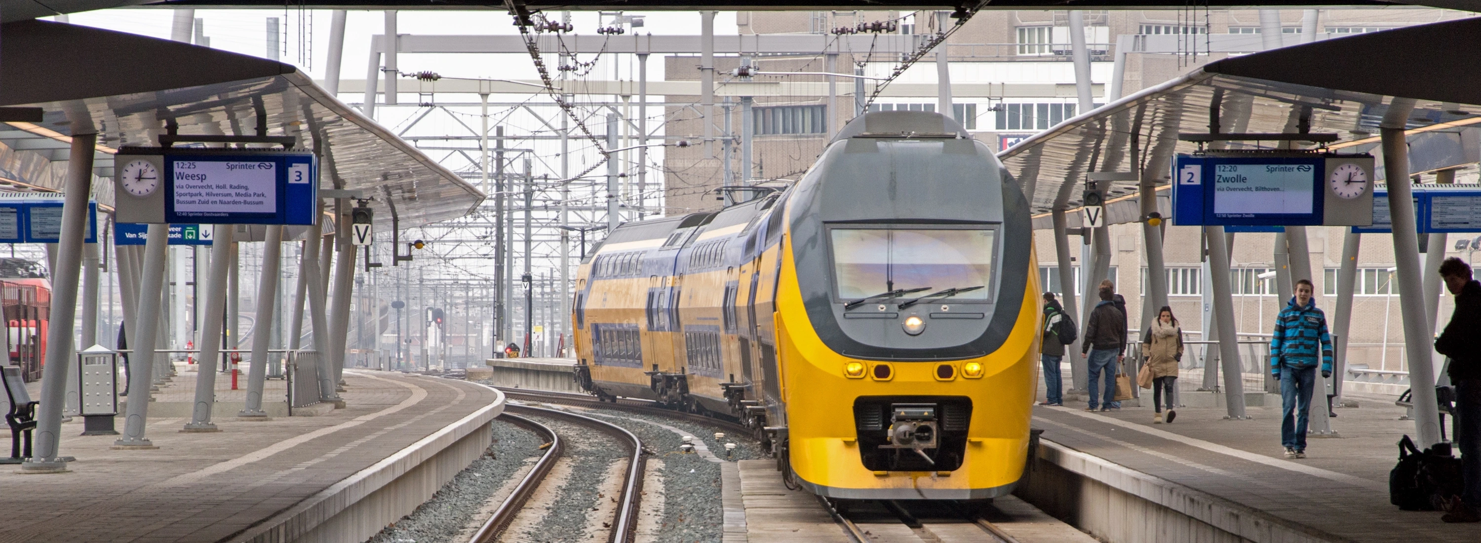 Nederlandse Spoorwegen geel-blauwe trein op modern station Amersfoort, representatief voor SafeU's professionele werkgebied